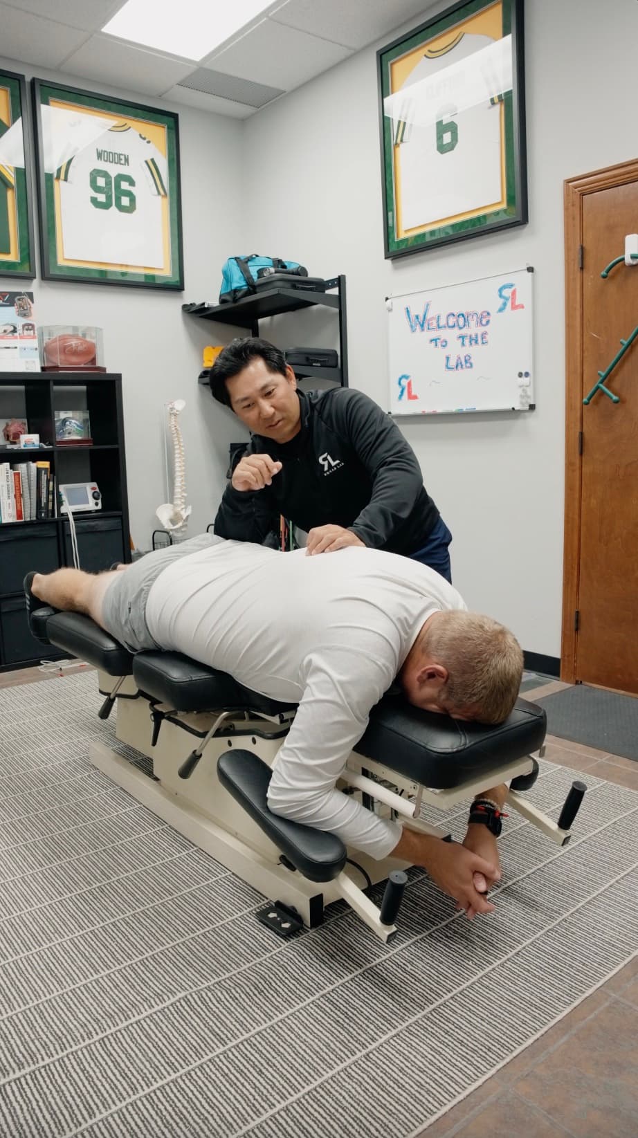 A Rehab Lab chiropractor adjusting a patient on the treatment table in Wauwatosa, WI